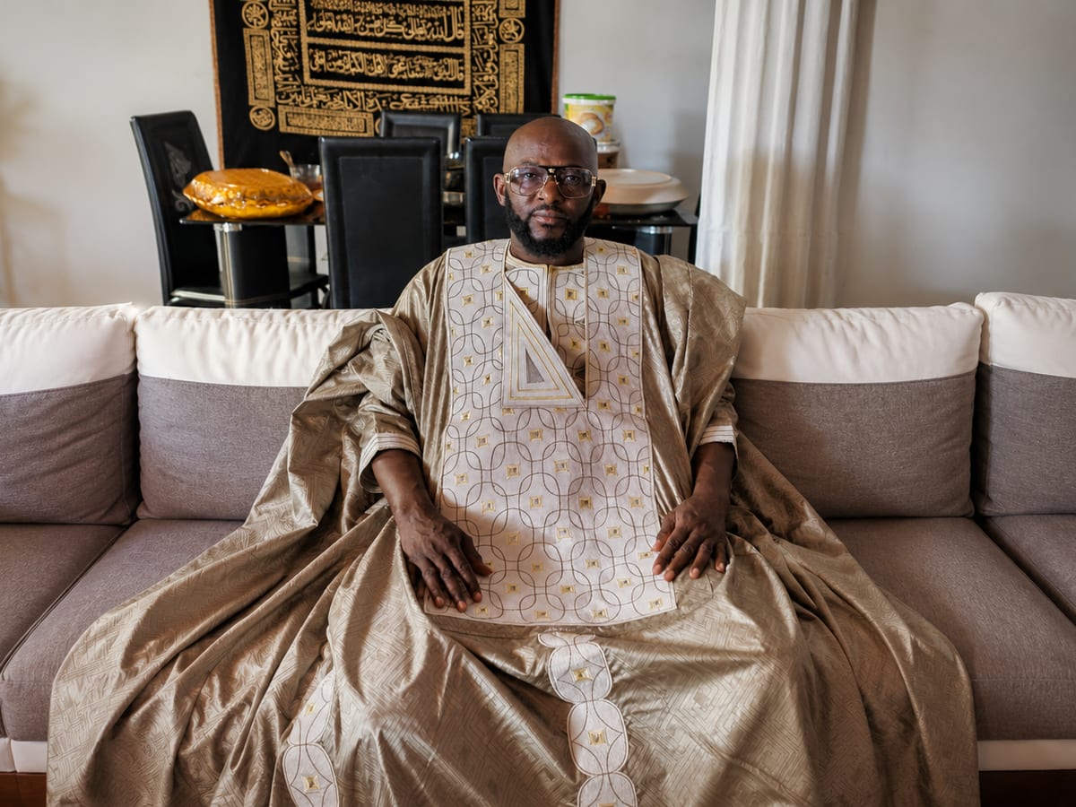 Marabout Djibril de túnica dourada, sentado na sua sala